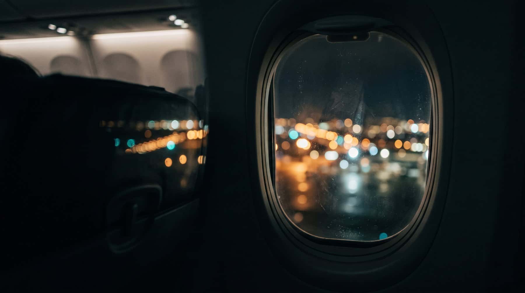 City lights seen through an airplane window at night before landing